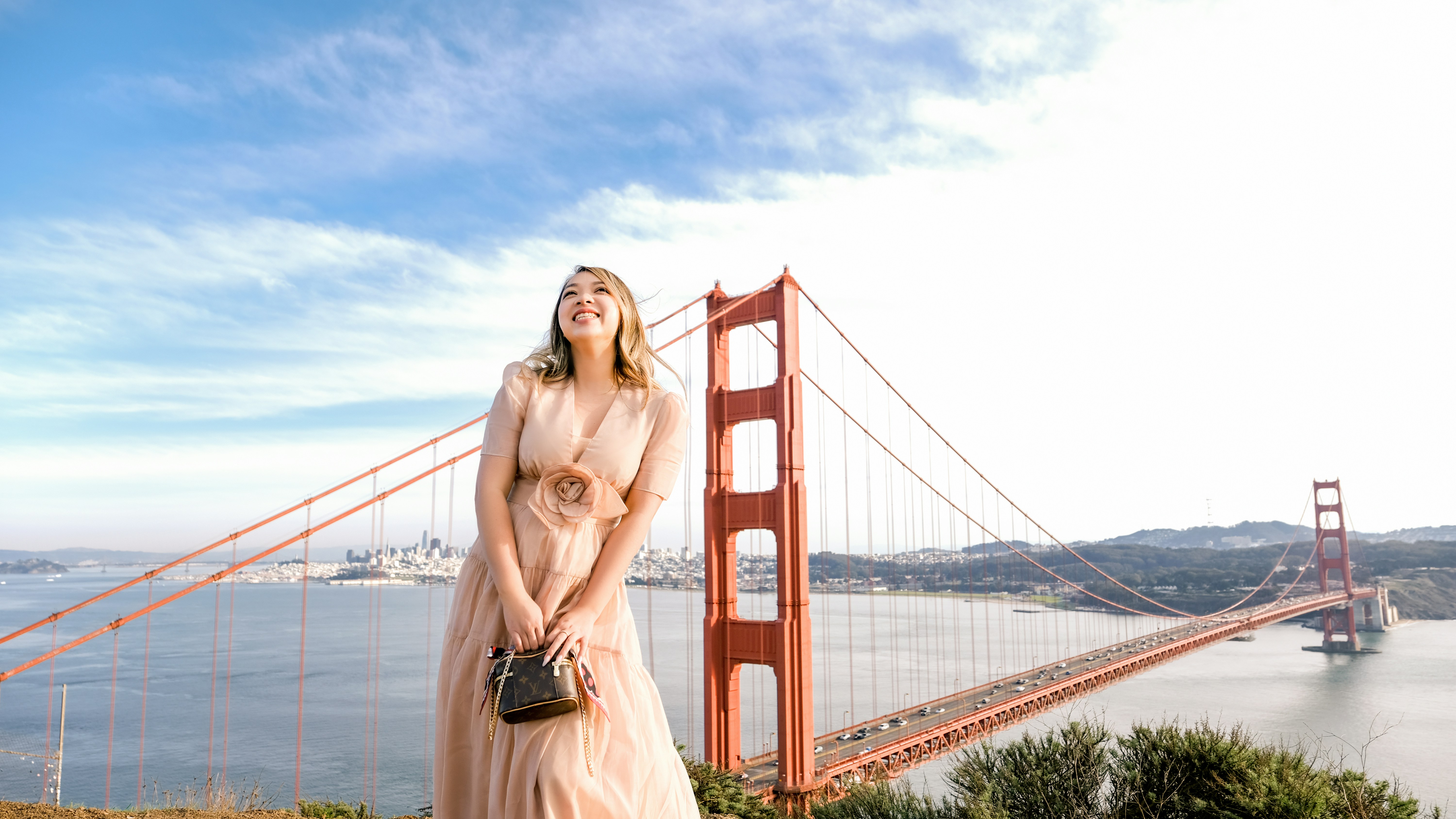 a woman standing in front of the golden gate bridge
