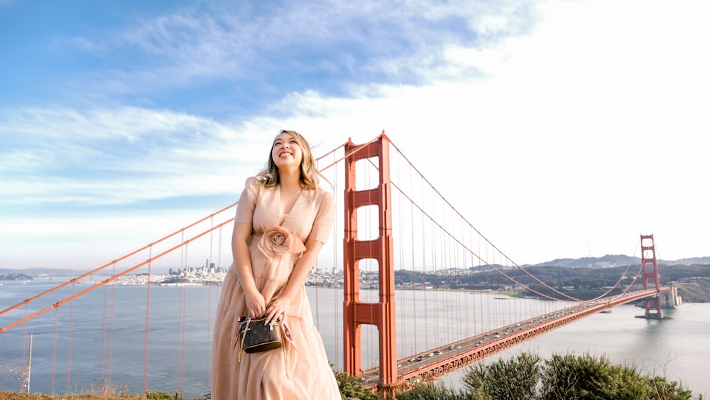 a woman standing in front of the golden gate bridge