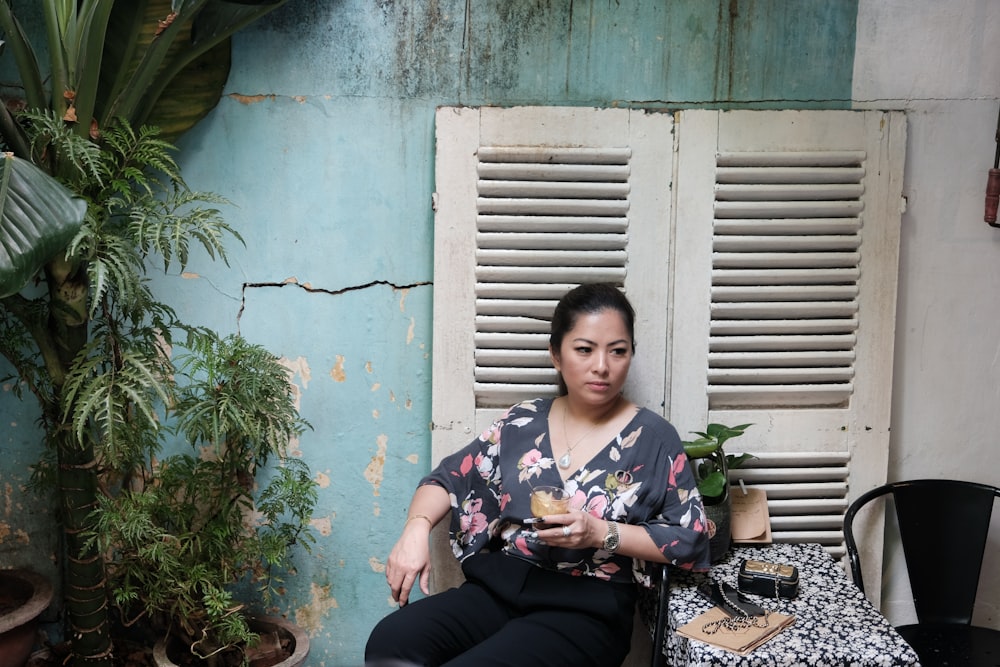 a woman sitting on a chair holding a plate of food