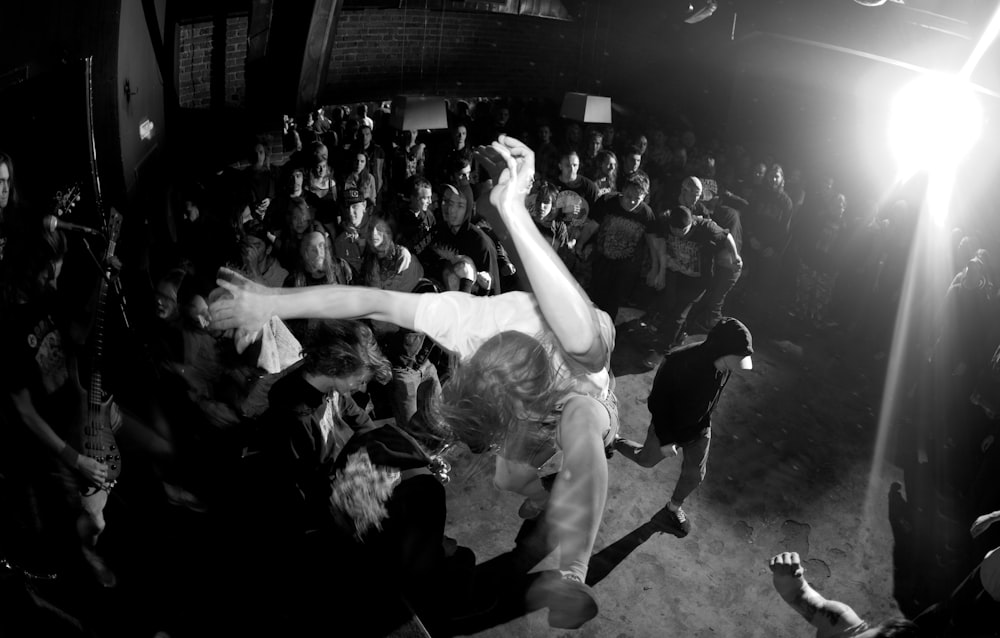 a crowd of people standing around a person on a stage