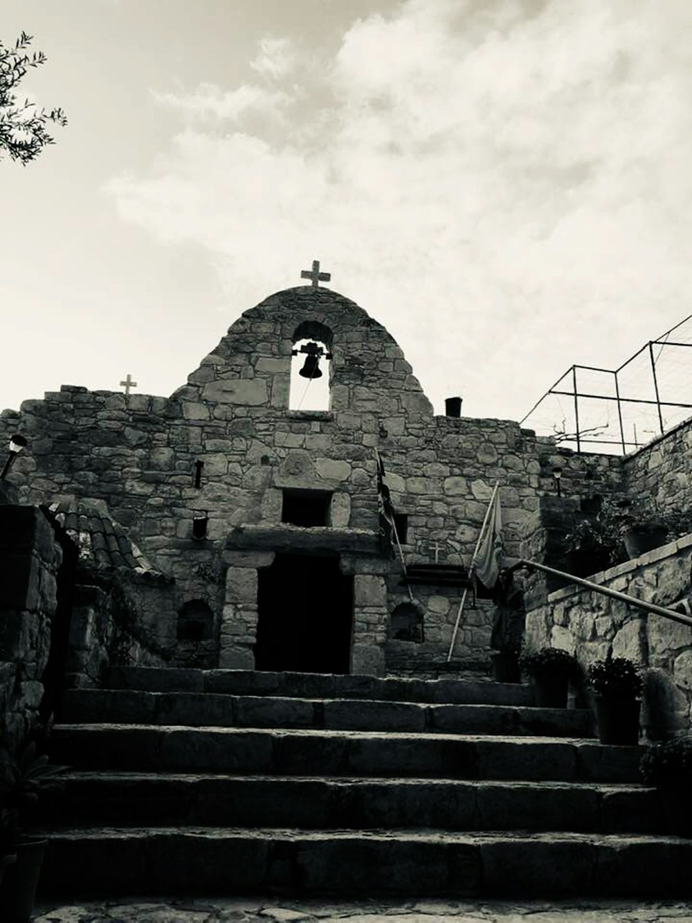 a black and white photo of a church with a bell