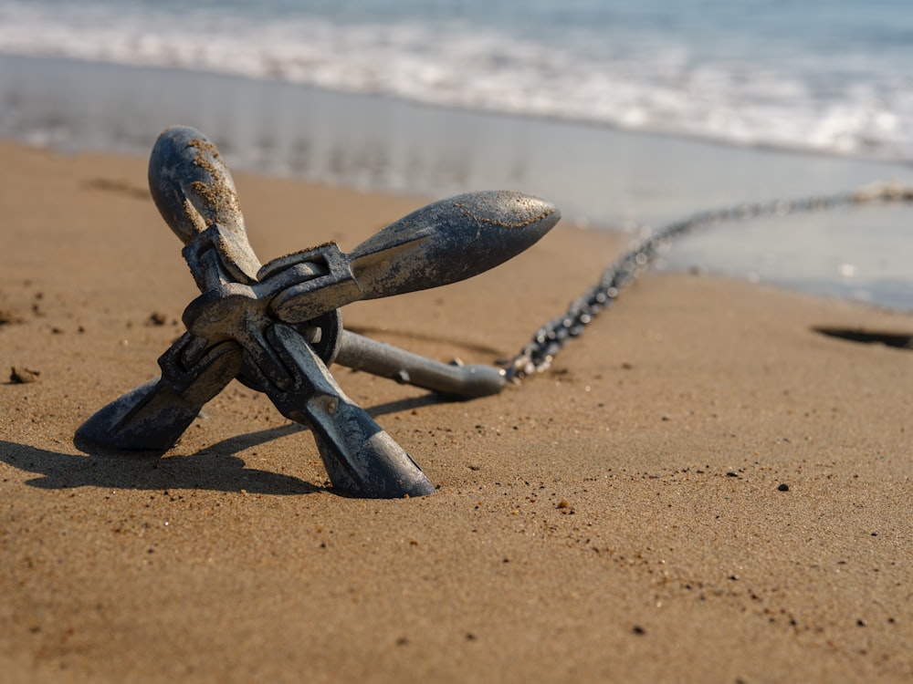 a metal object sitting on top of a sandy beach