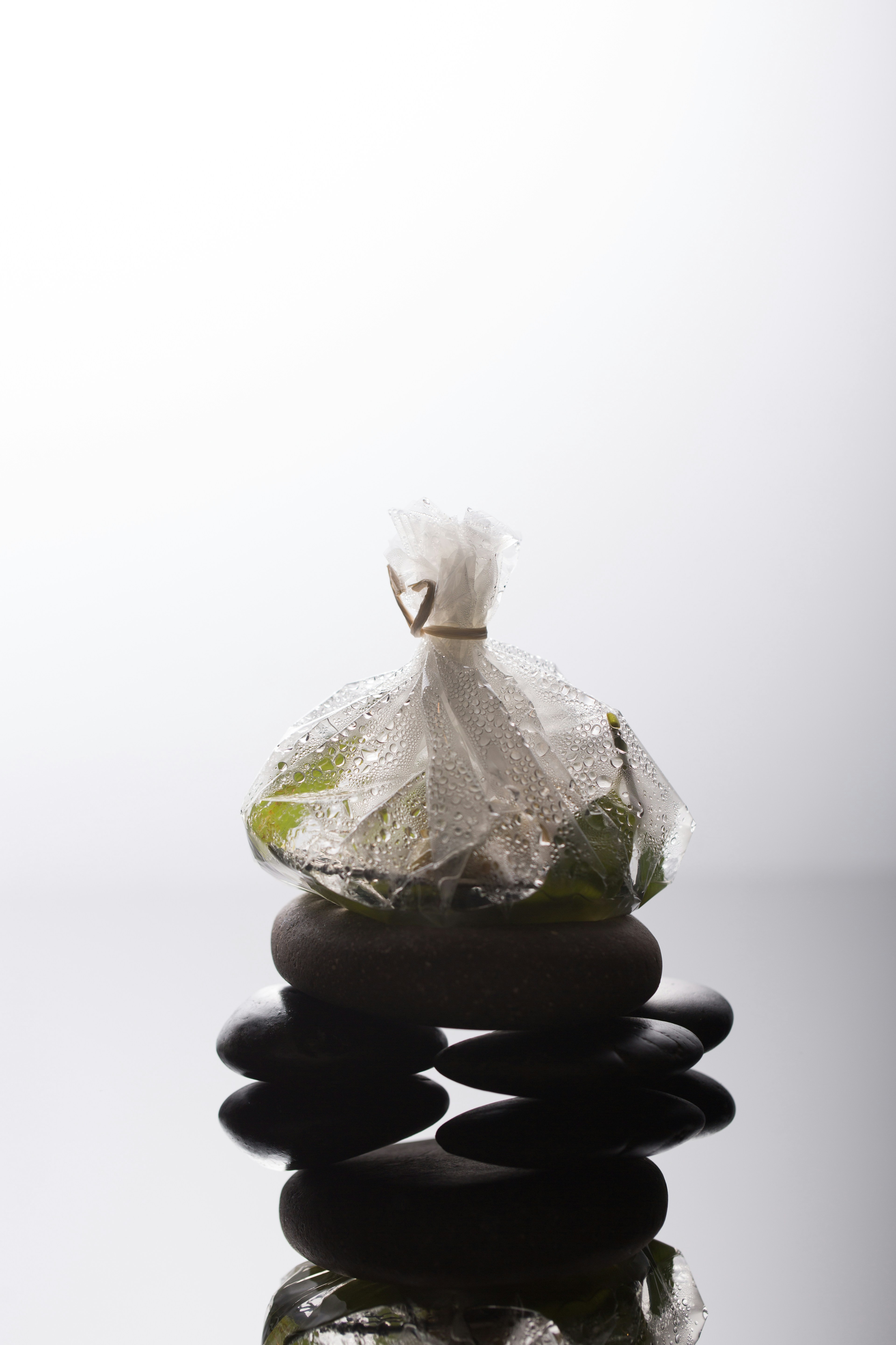 a bag of garbage sitting on top of a pile of rocks