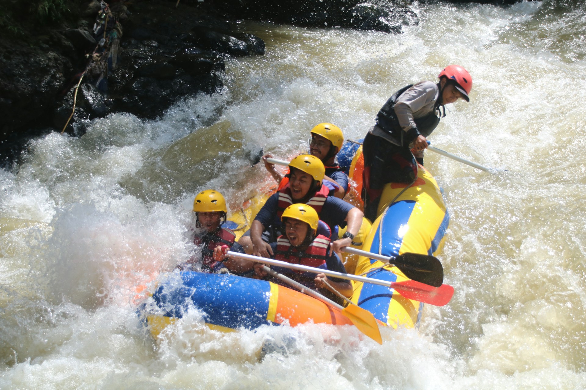 A group of excited rafters navigating through exhilarating rapids on a sunny day.