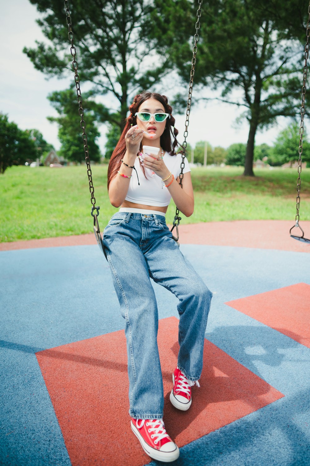 a woman sitting on a swing in a park