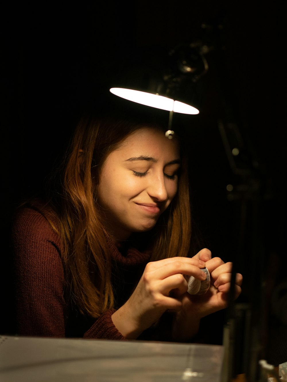 a woman sitting at a table with a light on her head