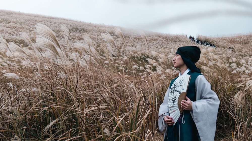 a woman standing in a field of tall grass