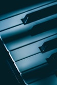 A close-up of vintage pipe organ keys bathed in moody blue light, hinting at epic soundscapes.