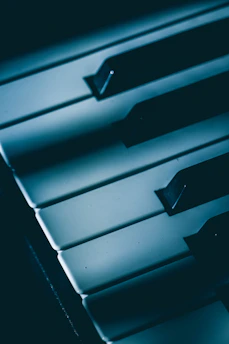 Close-up of piano keys illuminated by warm, dramatic lighting