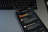 A smartphone displaying the iPhone storage management screen is placed on a laptop keyboard. The screen shows details about the storage used by different applications, with a focus on iCloud Photos. The image conveys a sense of digital organization and technology usage.