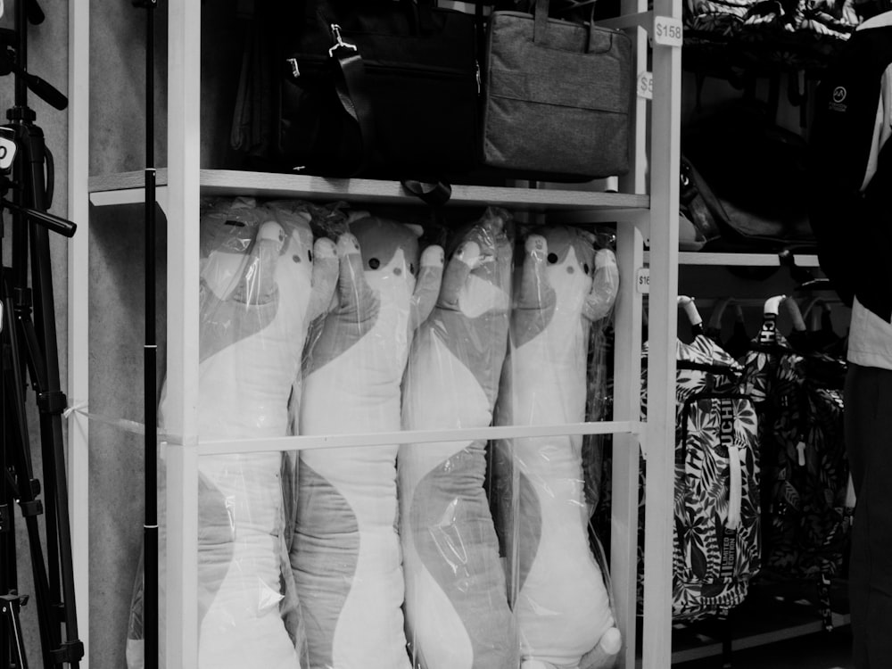 Fotografía en blanco y negro de una persona parada frente a un estante de zapatos