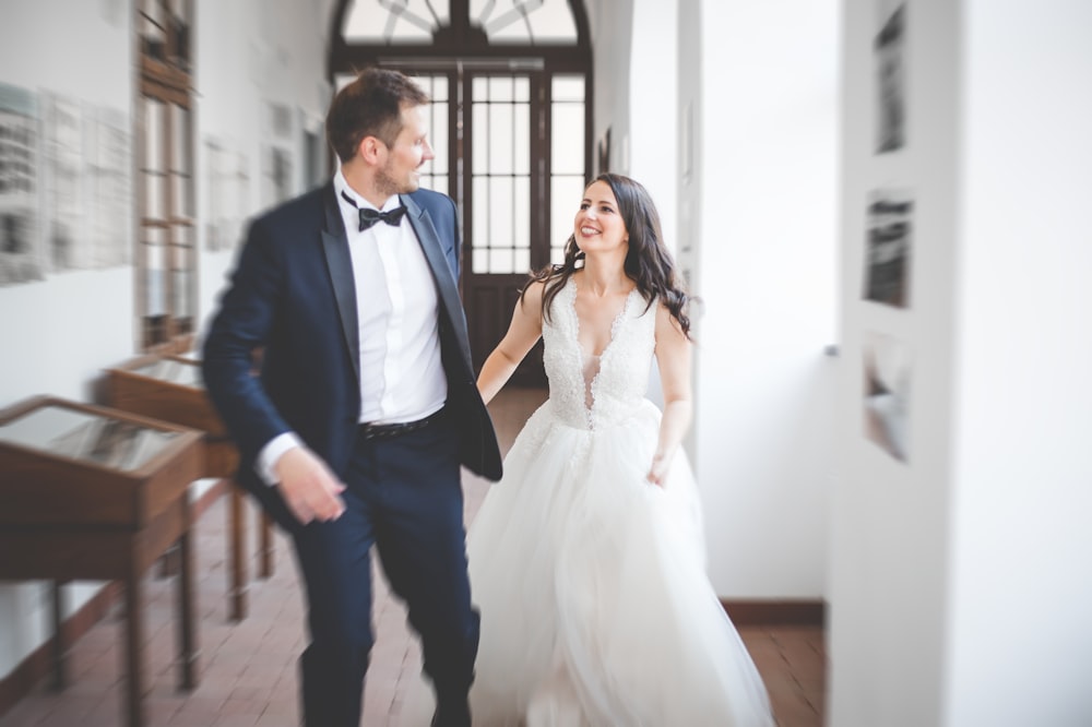 a bride and groom walking through a hallway