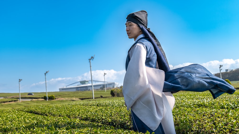a man in a kimono walking through a field