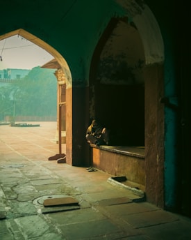 A stylish traveler enjoying a quiet moment at a hidden London courtyard bathed in soft afternoon light.
