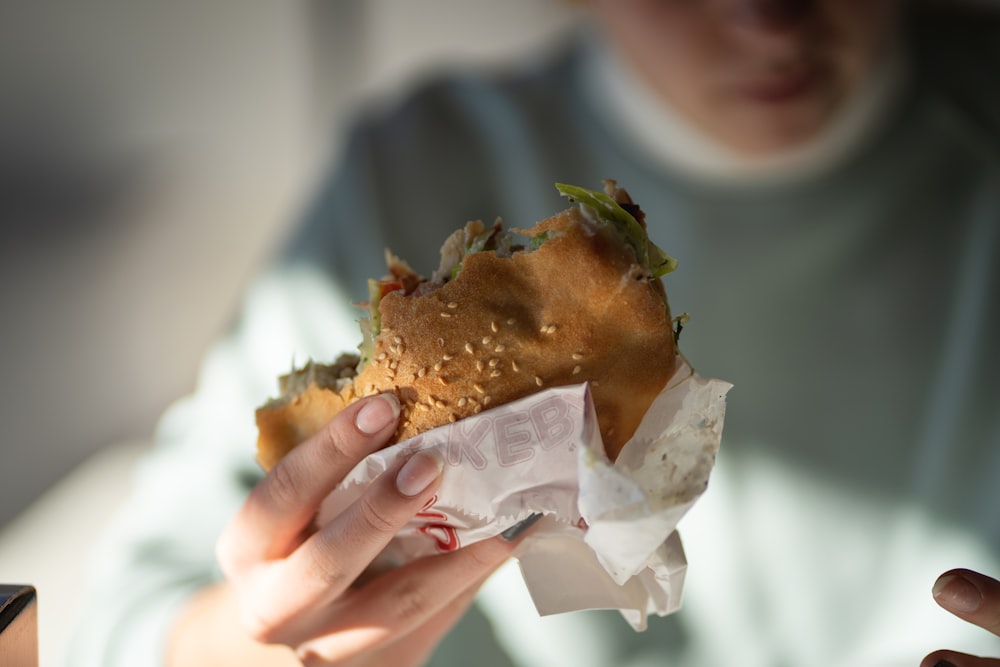 a close up of a person holding a sandwich