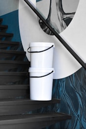 a white bucket sitting on top of a set of stairs