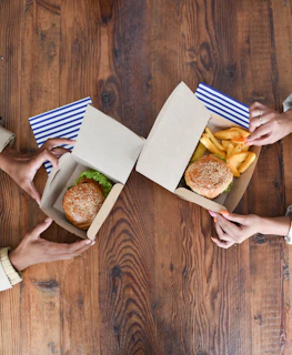 a group of people holding open boxes of food
