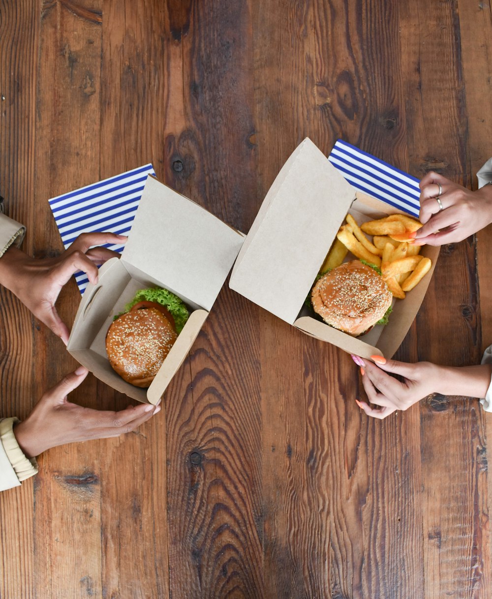 a group of people holding open boxes of food