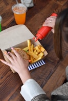 a woman sitting at a table with a box of food