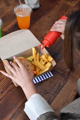 a woman sitting at a table with a box of food
