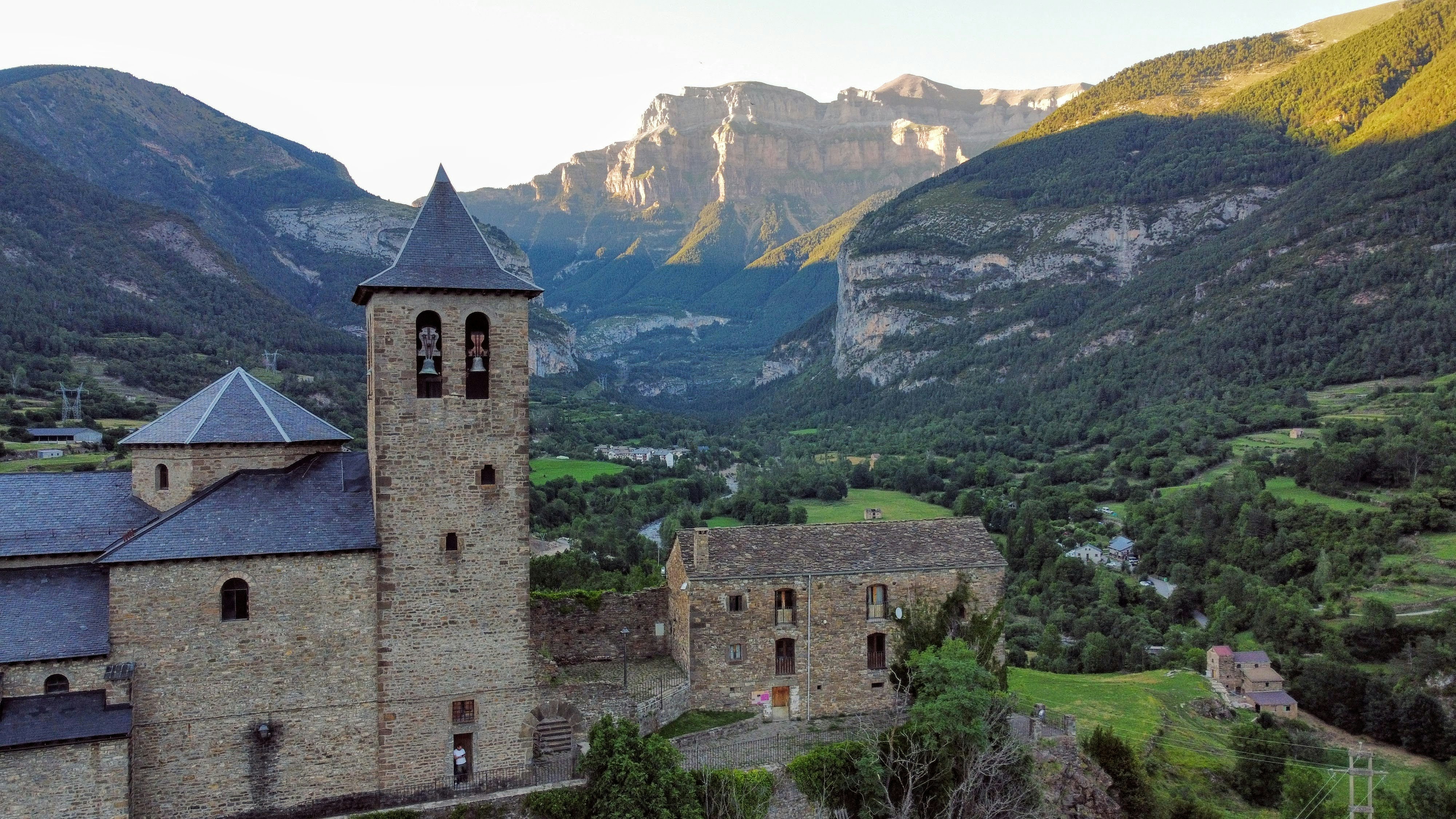 a castle in the middle of a valley with mountains in the background