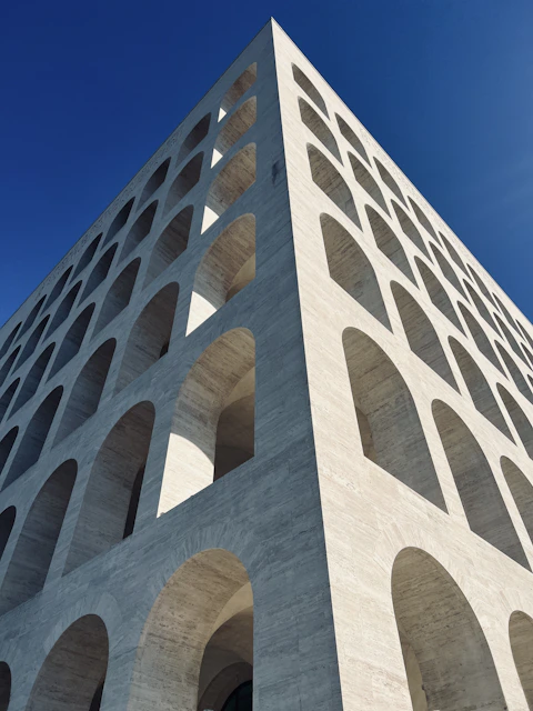 a tall white building with arches and a sky background