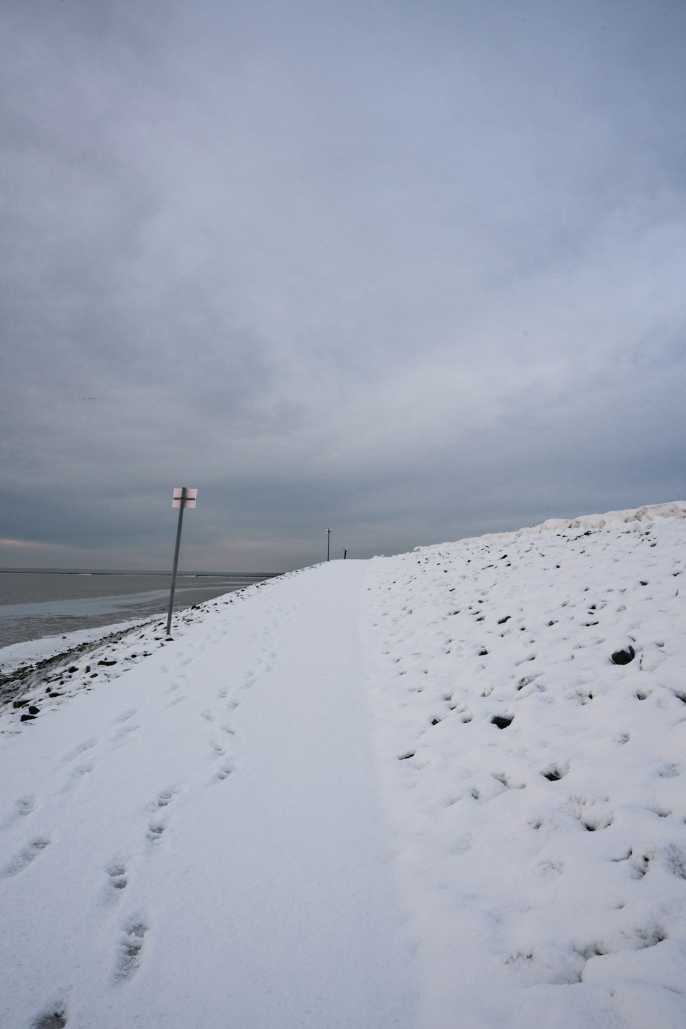 une plage enneigée avec un lampadaire au loin