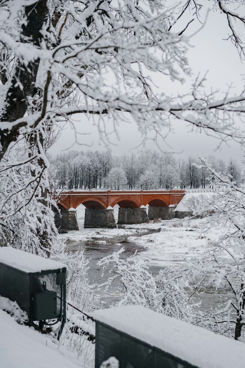 a bridge that is over a river in the snow