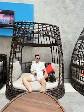 An elegant traveler enjoying a quiet moment on a velvet blue lounge chair.