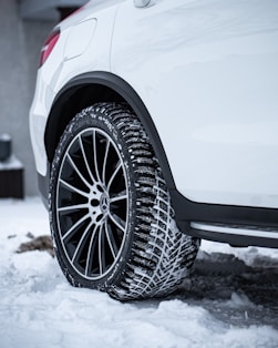 a white car is parked in the snow