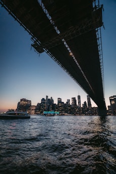 a boat under a bridge with a city in the background