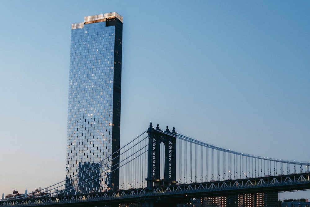 a very tall building next to a very tall bridge