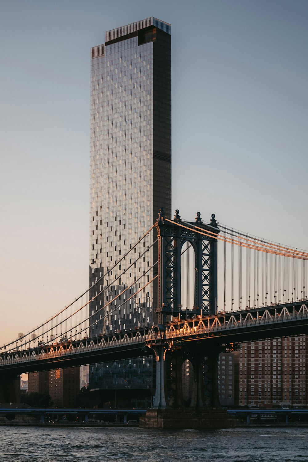 a large bridge with a very tall building in the background