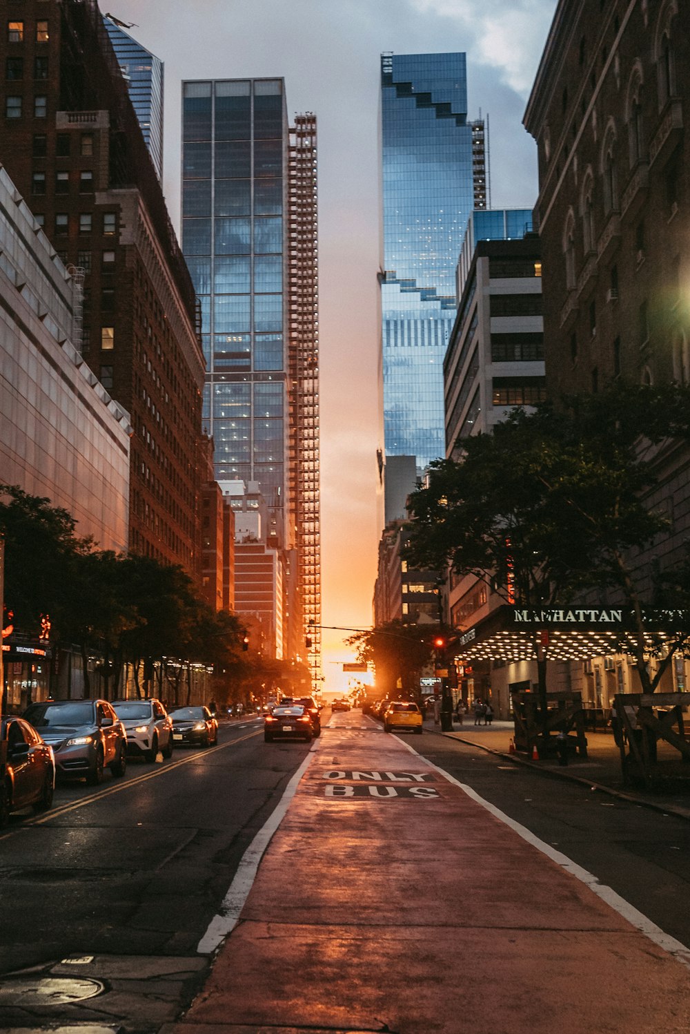 Eine Stadtstraße bei Sonnenuntergang mit hohen Gebäuden