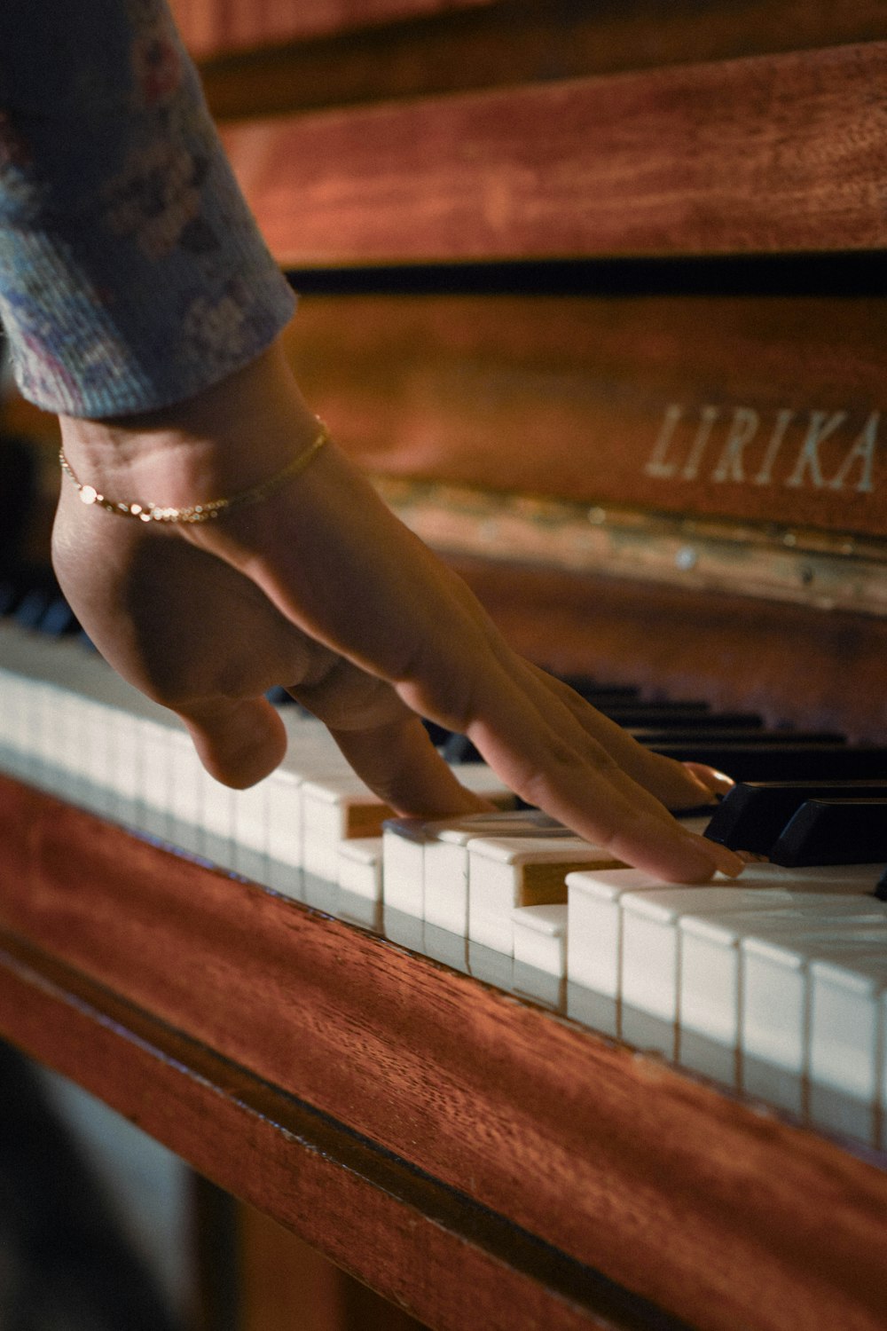a person's hand on top of a piano
