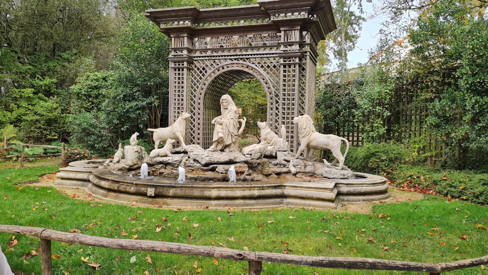 a garden with a fountain and statues in it