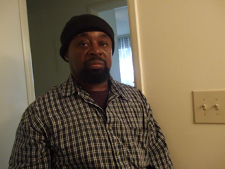 A friendly electrician talking with a homeowner at the front door, clipboard in hand.