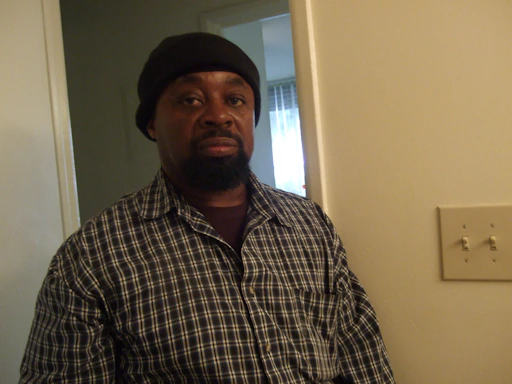 A friendly electrician talking with a homeowner at the front door, clipboard in hand.