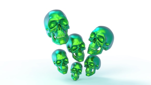 Several glossy, green skulls are floating against a white background. The skulls have a metallic appearance with smooth, shiny surfaces and are arranged in a visually striking pattern.