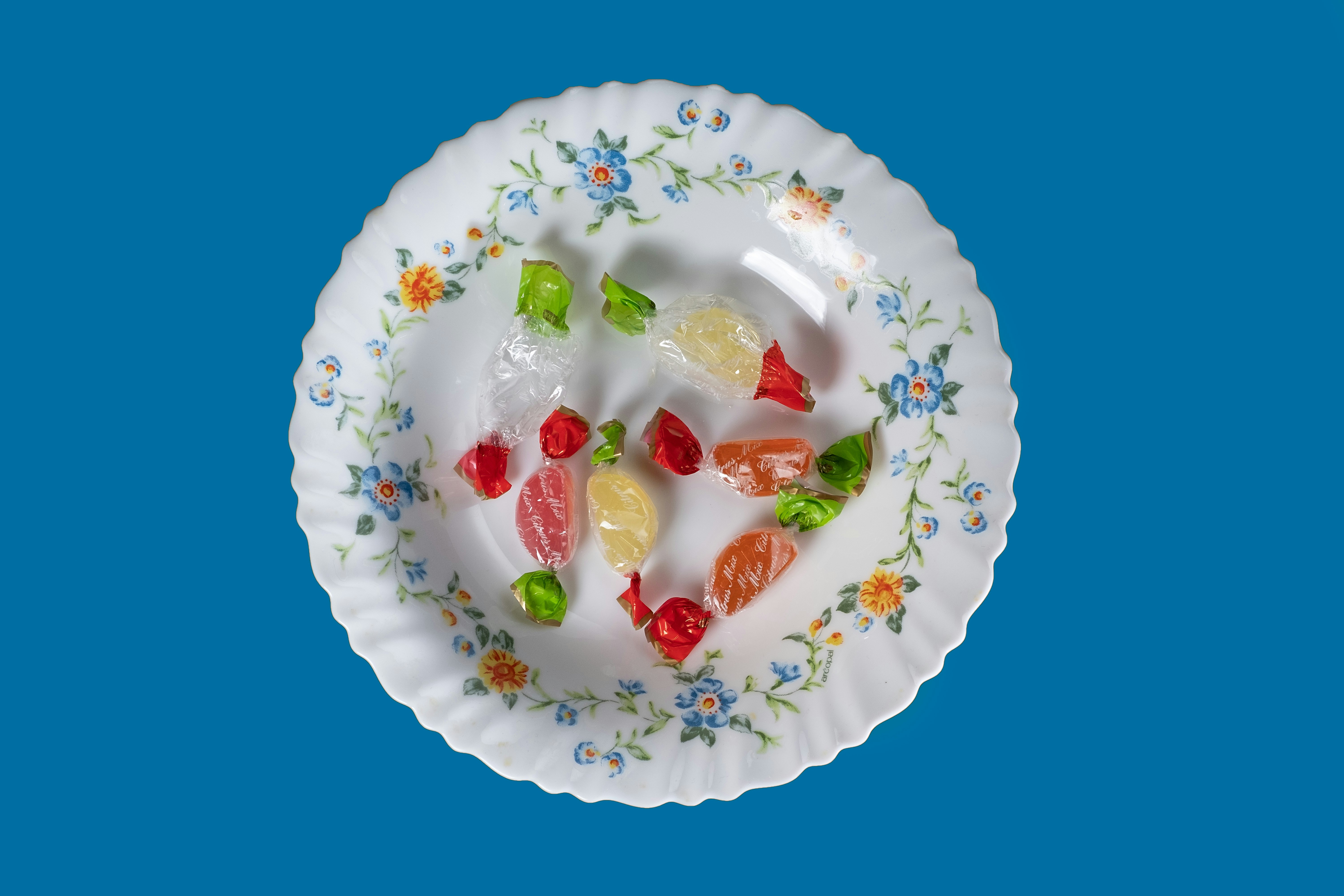 a white plate topped with gummy bears on top of a blue background