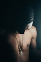 a shirtless man with a necklace on his chest