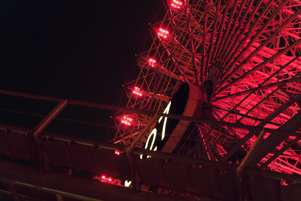 a red ferris wheel lit up at night