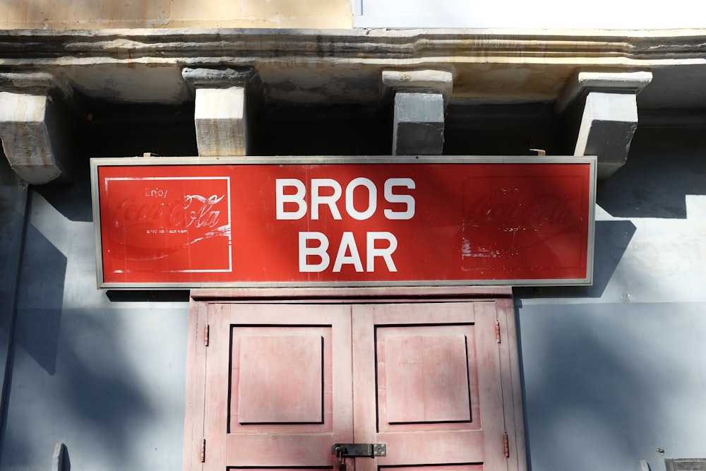 a red sign that says bros bar above a red door