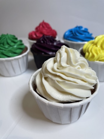 A colorful array of cupcakes topped with various frostings.