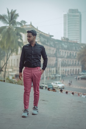 A confident young man wearing slim-fit cargo pants, walking through a vibrant urban street in Madurai.