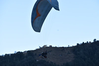 A solo paraglider gliding peacefully above Berber villages and rugged valleys.