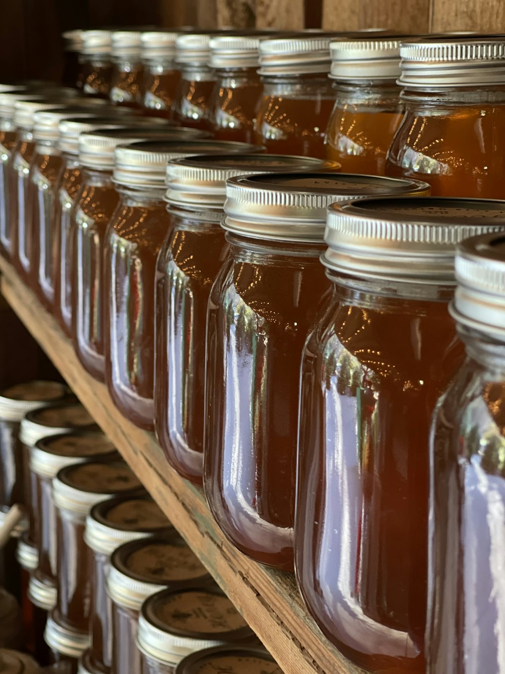 rows of jars of honey sit on a shelf