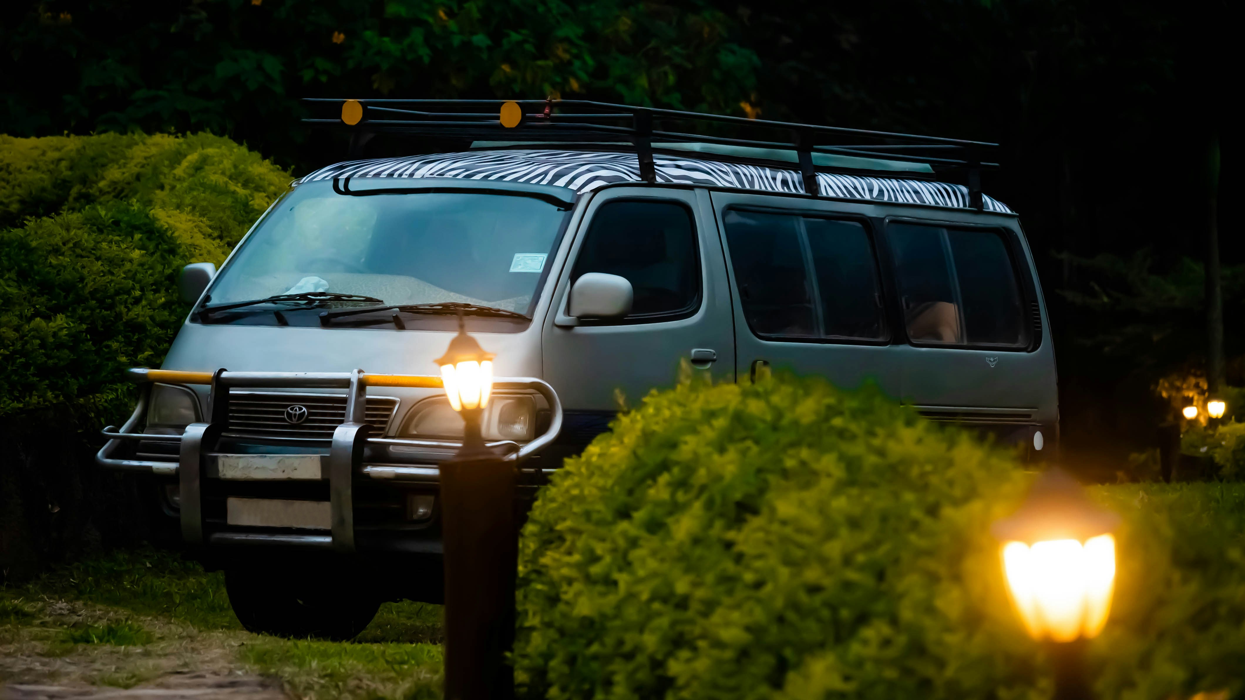 a van is parked in the dark with its lights on, A tourist van parked in Silverback Lodge in Bwindi Impenetrable Forest