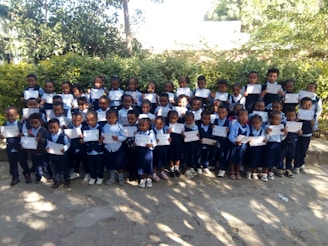 A group photo of primary school students proudly holding their certificates during a school event