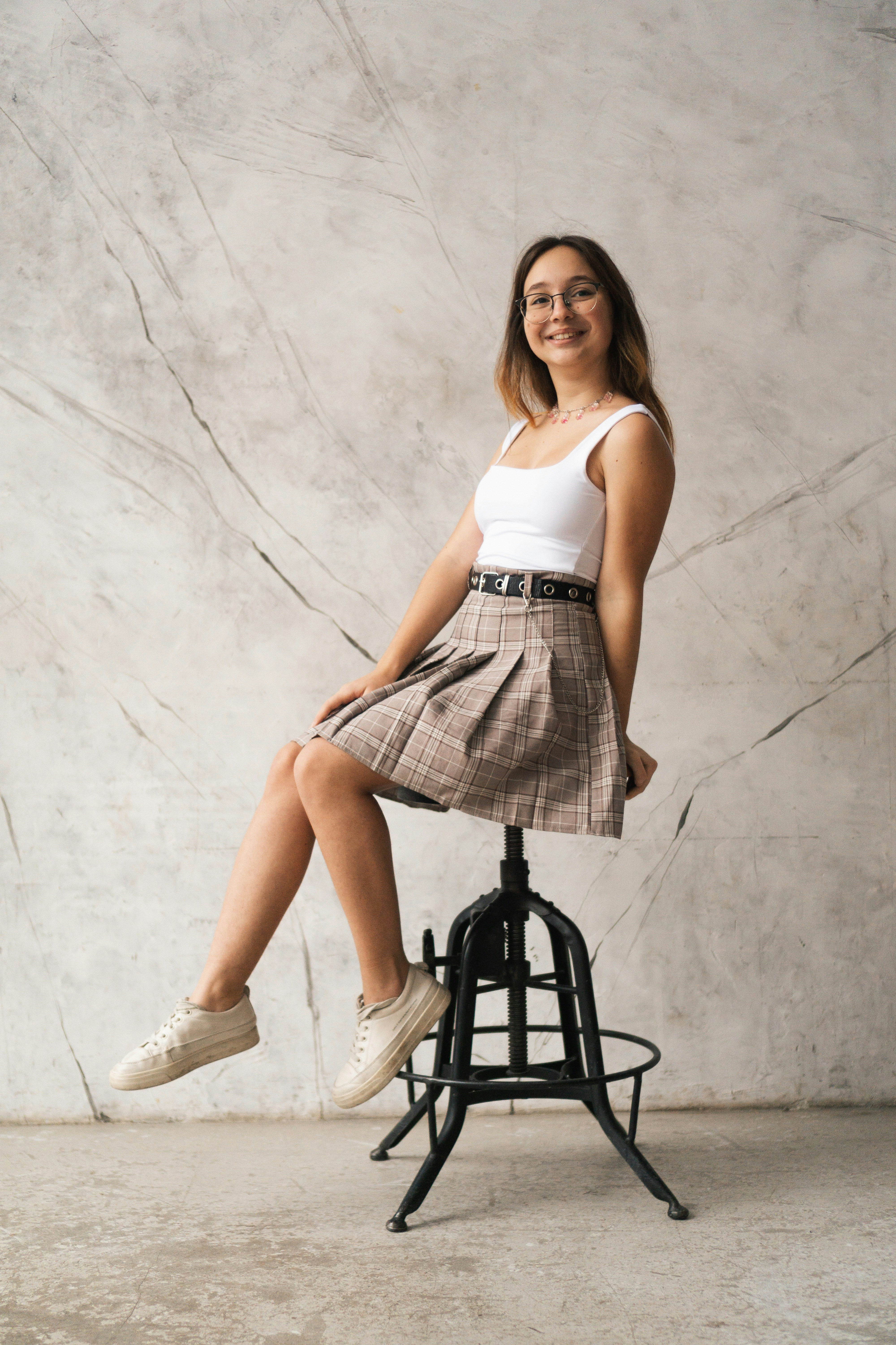 a woman sitting on a stool posing for a picture